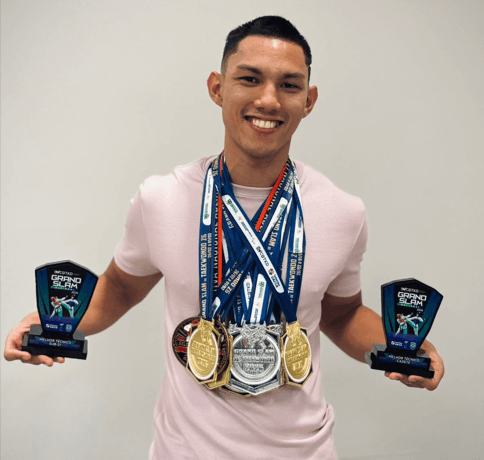 Victor Kazuya, atleta profissional de Taekwondo, exibindo medalhas e troféus de campeão